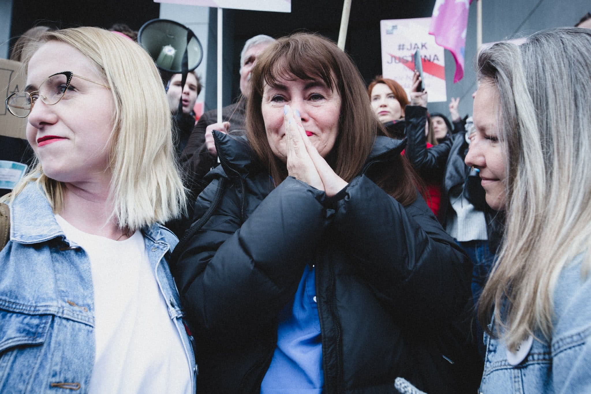 Od lewej - Kinga Jelińska, Justyna Wydrzyńska i Natalia Broniarczyk. Wokół aktywistek tłum prostestujących za Justyną osób. Justyna ma załzawione od wzruszenia oczy i zasłania sobie usta w geście zaskoczenia.