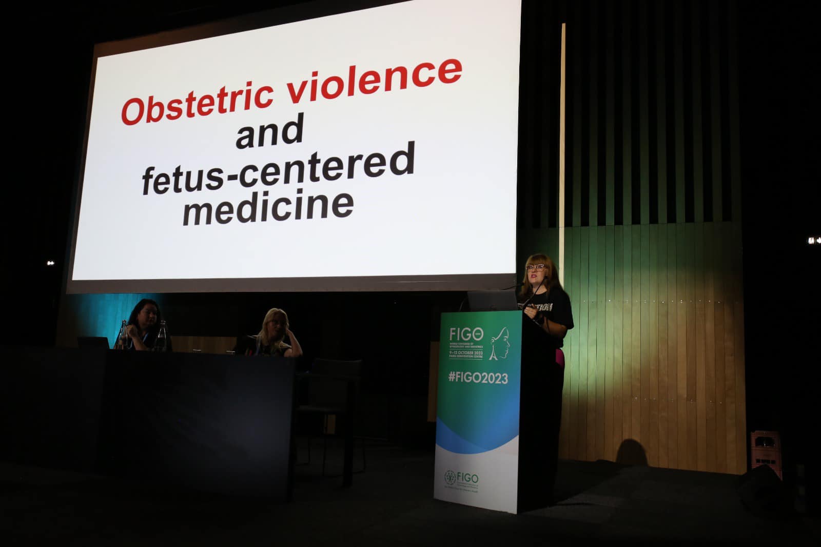 Kinga Jelińska przemawia na konferencji FIAPAC - w tle duży ekran z napisem - Abortion Here, There and Everywhere.