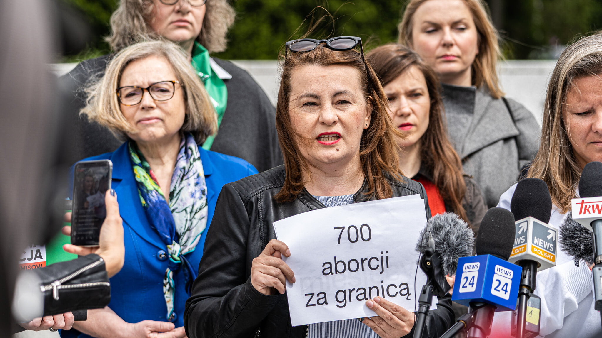 Wanda Nowacka, Justyna Wydrzyńska i Natalia Broniarczyk stoją przed mikrofonami mediów. W tle widać Martę Lempart oraz sejm RP.