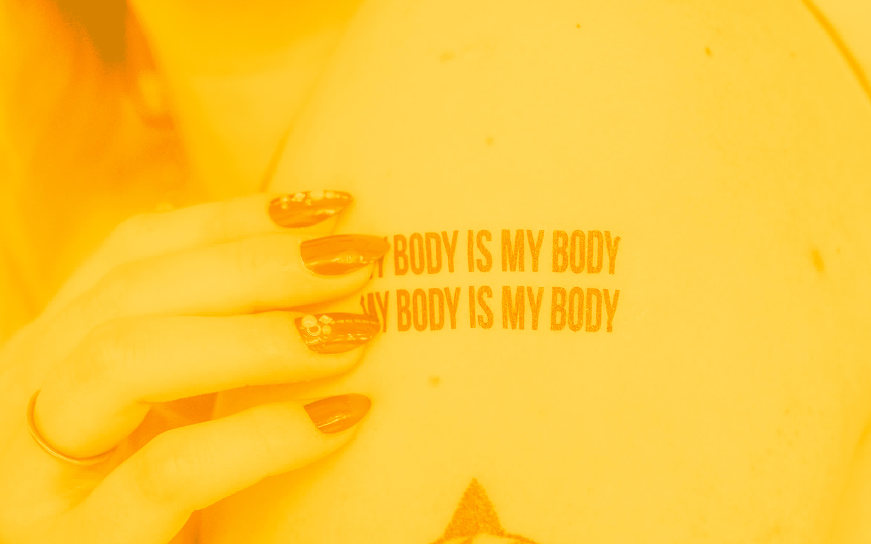Ramię dziewczyny z tatuażem - my body is my body - moje ciało, jest moje.