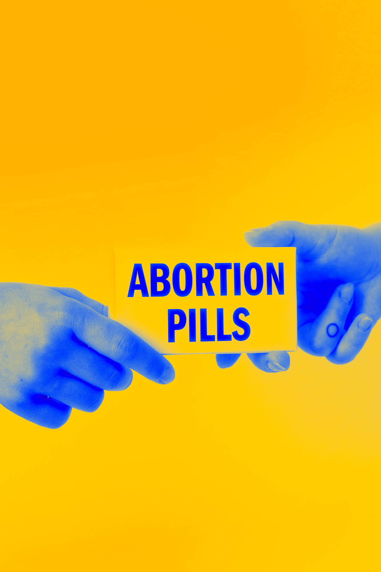 Zdjęcie w kolorach Ukraińskiej flagi - dłonie przekazują sobie pudełko z tabletkami aborcyjnymi.